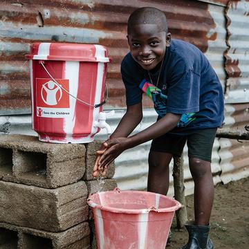 A boy washes his hands using a clean water kit. A boy washes his hands using a clean water kit.