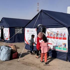 A tent with people outside at the Afghanistan and Iran border that is a child friendly space supported by Save the Children. A tent with people outside at the Afghanistan and Iran border that is a child friendly space supported by Save the Children.
