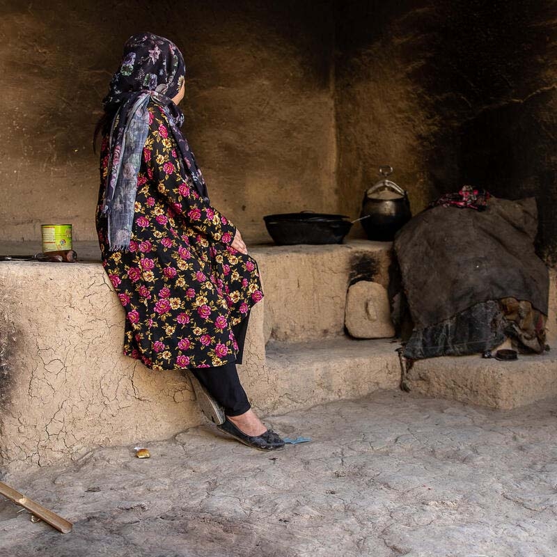 In Afghanistan, a girl sits alone and looks at the wall of a dark home. In Afghanistan, a girl sits alone and looks at the wall of a dark home.