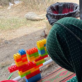 Two girls with their backs to the camera in Afghanistan play with blocks Two girls with their backs to the camera in Afghanistan play with blocks