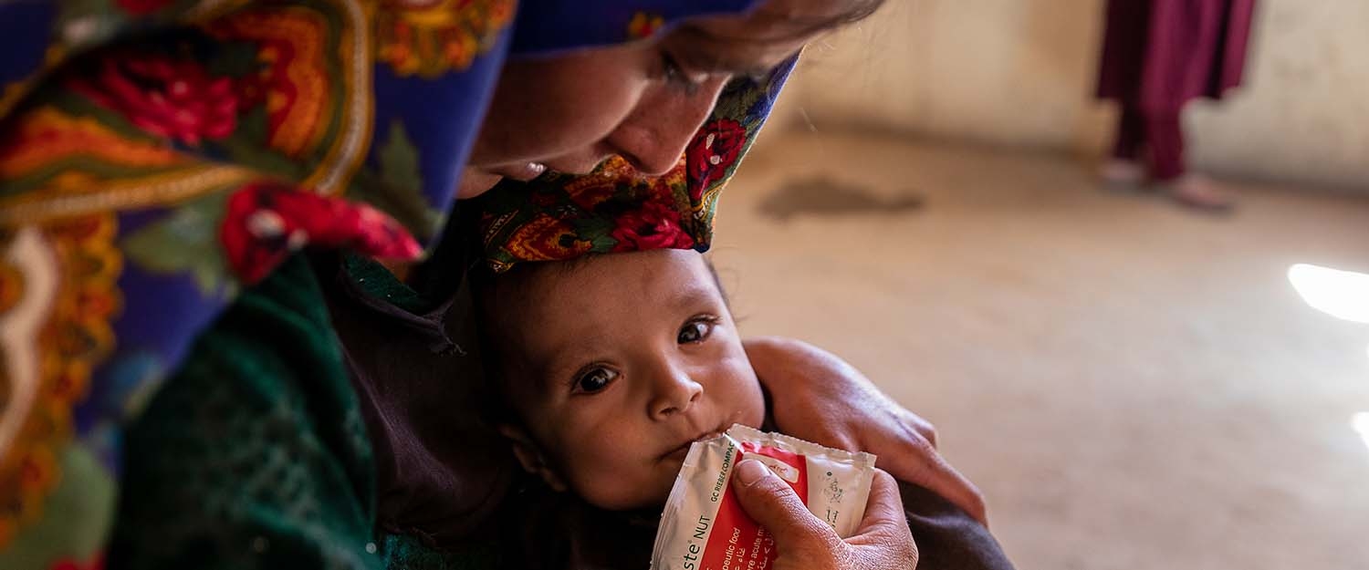 In Afghanistan, a mother feeds her daughter with therapeutic food used to treat severe acute malnutrition In Afghanistan, a mother feeds her daughter with therapeutic food used to treat severe acute malnutrition