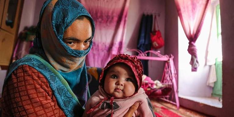 Afghanistan, a young mother holds one of her 3-month-old twin baby girl Afghanistan, a young mother holds one of her 3-month-old twin baby girl