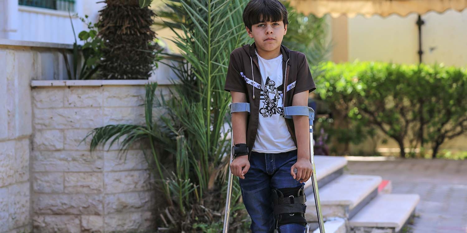 Palestine, a young boy on crutches steers into the camera Palestine, a young boy on crutches steers into the camera