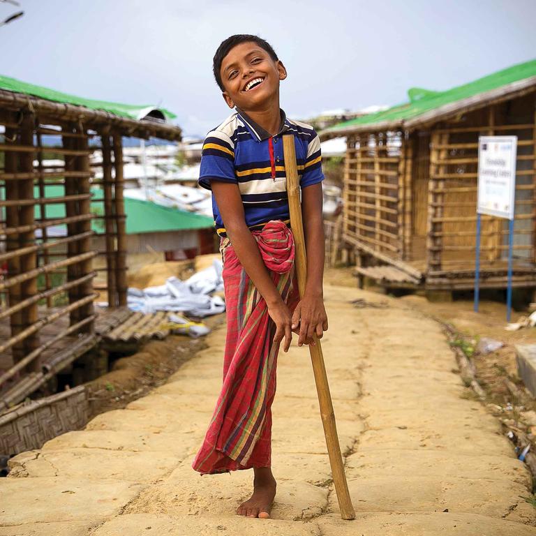 A boy stands and smiles while standing on one leg in Cox's Bazar, Bangladesh. A boy stands and smiles while standing on one leg in Cox's Bazar, Bangladesh.