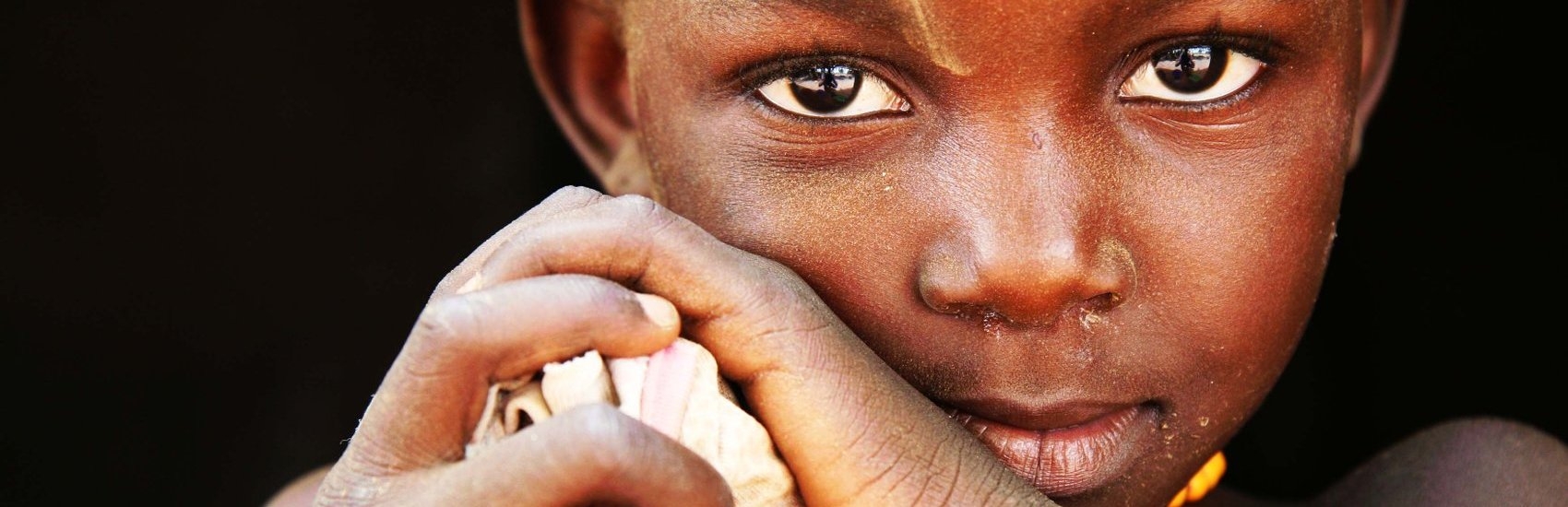 Portait of Nemata, age four, at her home in Kaya, Burkina Faso. Nemata tells Save the Children about her family’s struggle to feed themselves due to last year’s drought and its effect on their crops. “Sometimes I don’t eat enough,” Nemata whispers. The family sold most of their livestock to feed themselves, but with nothing to harvest, Nemata’s family faces hunger. Photo credit: Hedinn Halldorsson/Save the Children, June 2012.