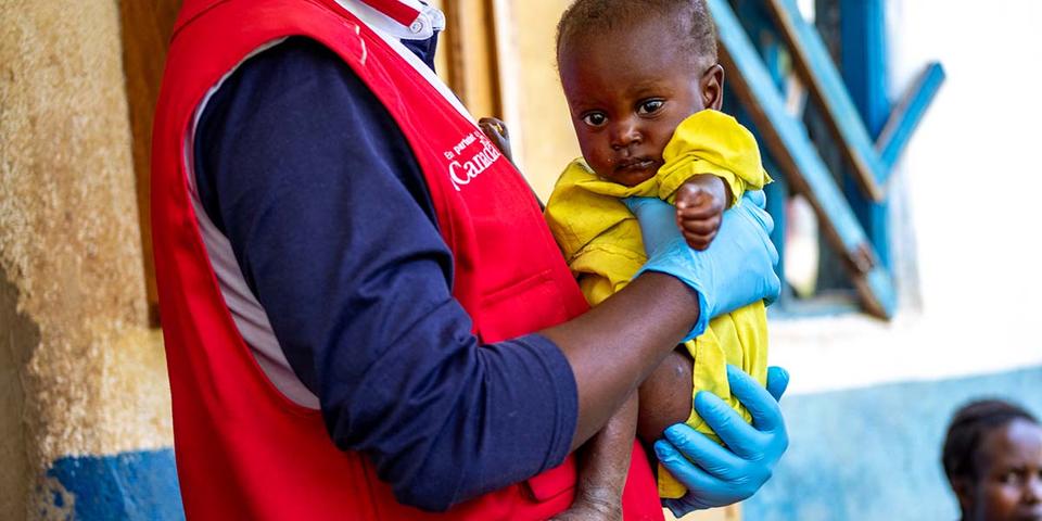drc-aid-worker-holds-child-ch11313979-rec drc-aid-worker-holds-child-ch11313979-rec