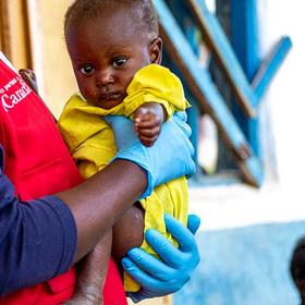 drc-aid-worker-holds-child-ch11313979-rec drc-aid-worker-holds-child-ch11313979-rec