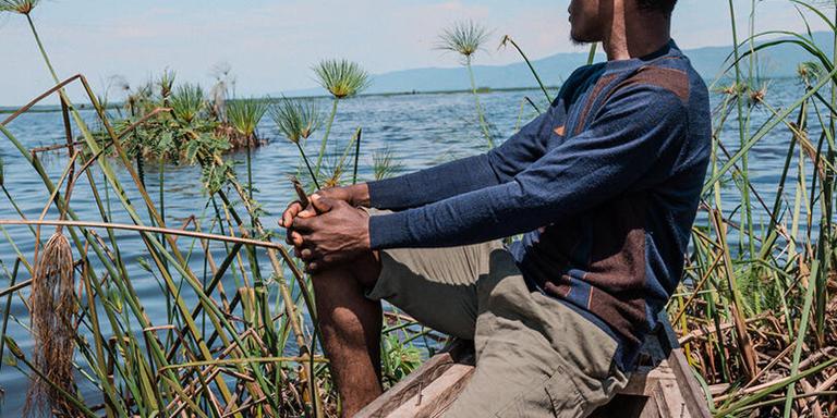 17-year-old Junior*, who spent eight months as a child solider in an armed group in 2018, sits in a canoe nearby his community in Eastern DRC. 17-year-old Junior*, who spent eight months as a child solider in an armed group in 2018, sits in a canoe nearby his community in Eastern DRC.