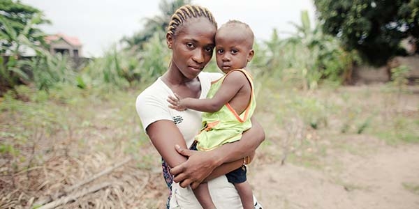 A mother holds her young African child, who suffered with pneumonia but was helped to recover, near a road in the Democratic republic of Congo. A mother holds her young African child, who suffered with pneumonia but was helped to recover, near a road in the Democratic republic of Congo.