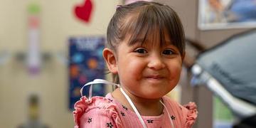 A 3-year-old girl smiles with a holding a handmade ball she made during an early learning class held by Save the Children. A 3-year-old girl smiles with a holding a handmade ball she made during an early learning class held by Save the Children.
