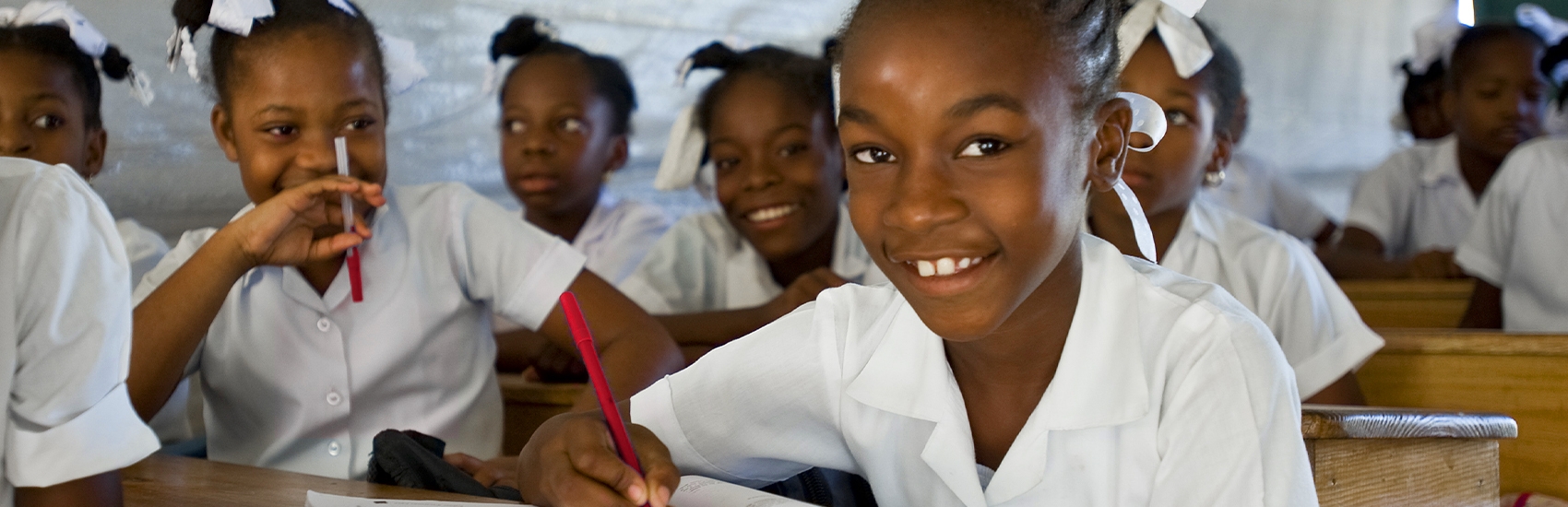A group of girls sit at their desks in a classroom in Africa. A group of girls sit at their desks in a classroom in Africa.