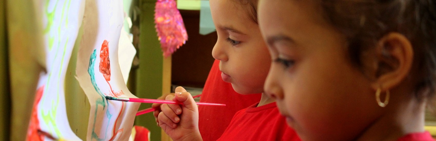 Close-up portrait of two young children painting in a Save the Children-supported art class in Egypt. Photo credit: Save the Children, 2012.