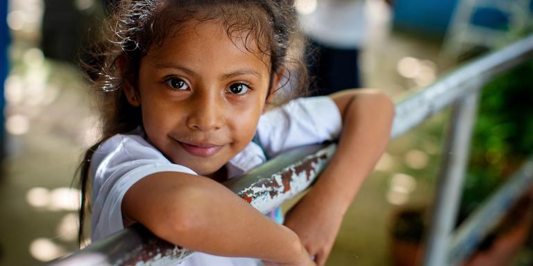 A young girl smiles and looks into the camera. A young girl smiles and looks into the camera.