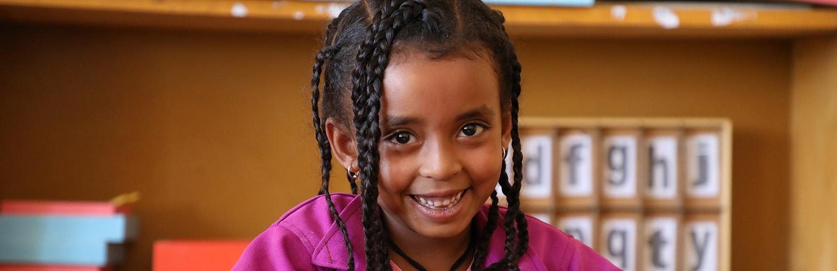 Ethiopia, Birtukan a little girl in braids, plays in a classroom.
