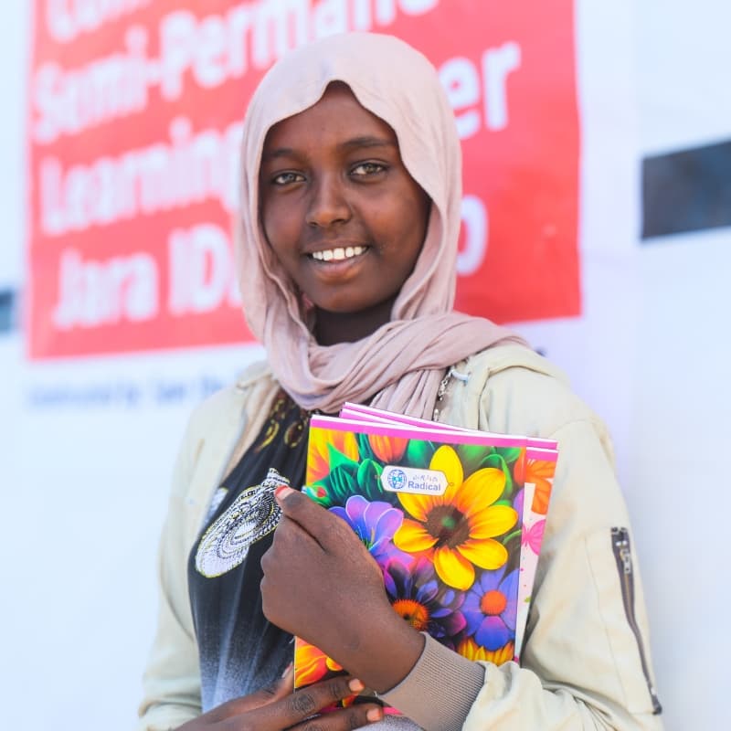 A fifth-grade girl holding her school notebooks in Ethiopia
