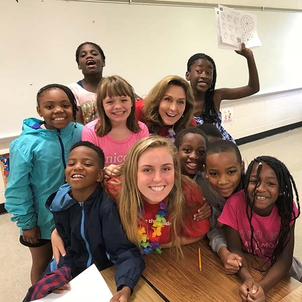 Fairfield County Leadership Council member smiling with a group of children. Fairfield County Leadership Council member smiling with a group of children.