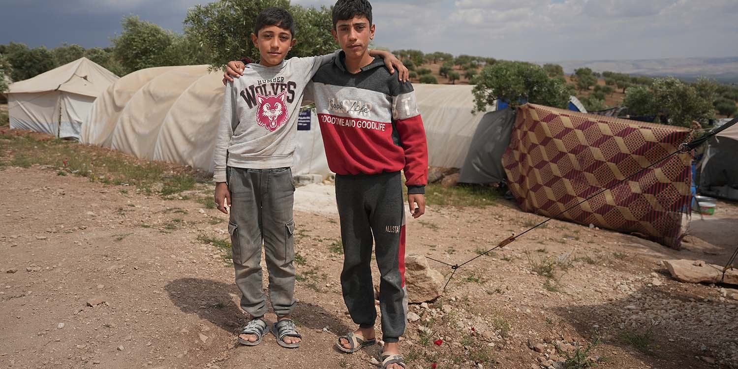 Syria, brothers stand together in front of a tent after an earthquake destroyed their home Syria, brothers stand together in front of a tent after an earthquake destroyed their home