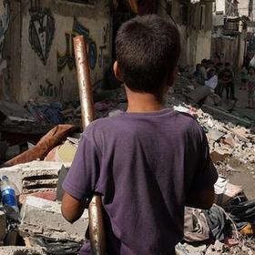 In Gaza, a boy faces a pile of rubble from buildings destroyed by the ongoing conflict. In Gaza, a boy faces a pile of rubble from buildings destroyed by the ongoing conflict.