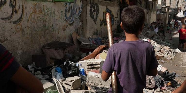 In Gaza, a boy faces a pile of rubble from buildings destroyed by the ongoing conflict. In Gaza, a boy faces a pile of rubble from buildings destroyed by the ongoing conflict.