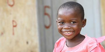 A girl smiling happily in a pink dress A girl smiling happily in a pink dress