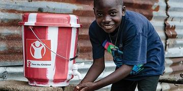 A child washes his hands in a clean water kit A child washes his hands in a clean water kit