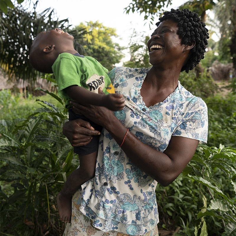A mother and her young child laugh.