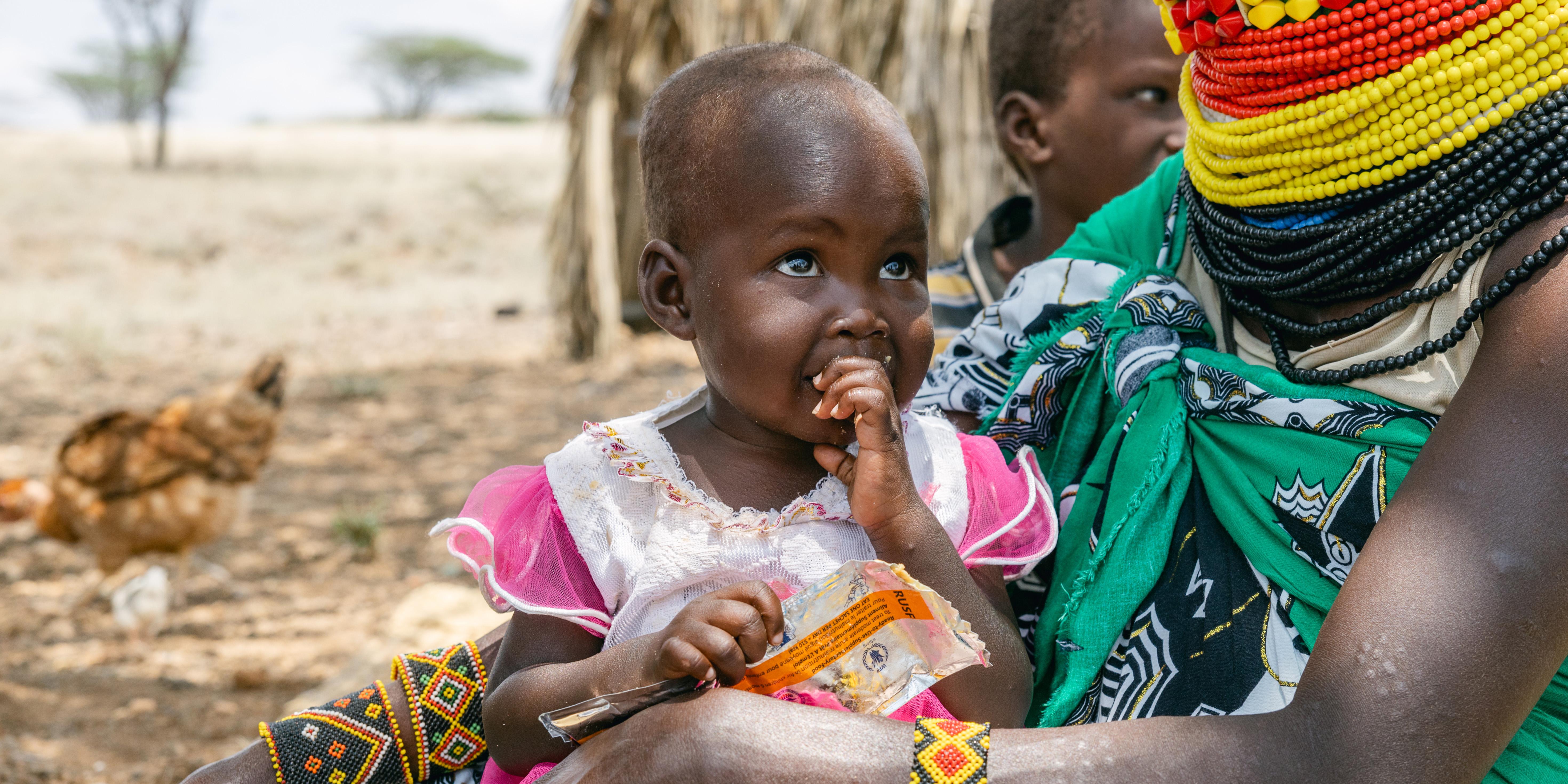 Ereng's mother feeds her fortified peanut paste