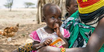 Ereng's mother feeds her fortified peanut paste Ereng's mother feeds her fortified peanut paste