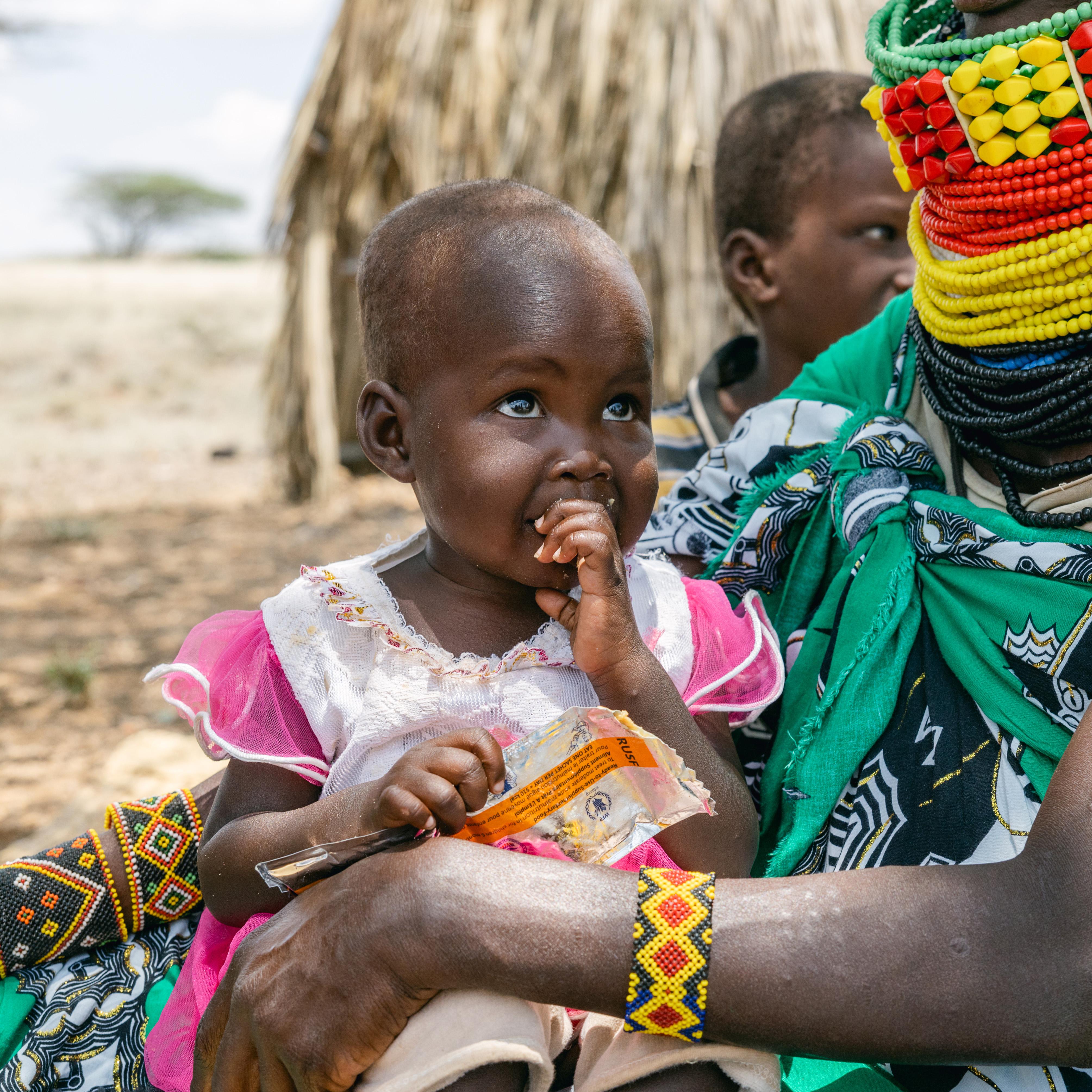 Ereng's mother feeds her fortified peanut paste