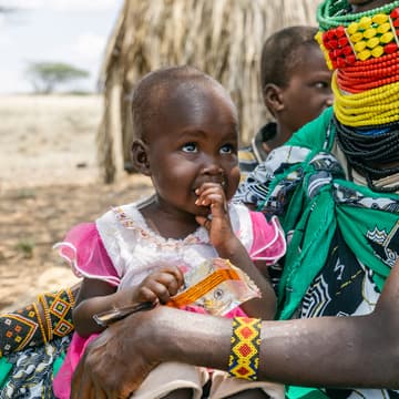 Ereng's mother feeds her fortified peanut paste Ereng's mother feeds her fortified peanut paste