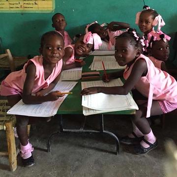 Young schoolchildren in Haiti, dressed in pink uniforms, are busy with their lessons. Young schoolchildren in Haiti, dressed in pink uniforms, are busy with their lessons.
