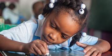 A young student practices letter writing in her preschool classroom in Port au Prince, Haiti. Save the Children worked to help Haiti rebuild its educational system and infrastructure following the destructive and deadly natural disasters. Photo Credit: Susan Warner/Save the Children 2016. A young student practices letter writing in her preschool classroom in Port au Prince, Haiti. Save the Children worked to help Haiti rebuild its educational system and infrastructure following the destructive and deadly natural disasters. Photo Credit: Susan Warner/Save the Children 2016.