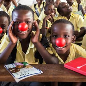 Smiling second-grade students in Haiti put red noses on to celebrate Red Nose Day. This fun fundraising campaign brings people together to raise money and change the lives of kids who need our help the most. We reached more than 15,000 girls and boys in need in urban Port-au-Prince, Haiti, working with teachers, parents and community leaders to improve the quality of education the children receive. Photo credit: Susan Warner/Save the Children, February 2016. Smiling second-grade students in Haiti put red noses on to celebrate Red Nose Day. This fun fundraising campaign brings people together to raise money and change the lives of kids who need our help the most. We reached more than 15,000 girls and boys in need in urban Port-au-Prince, Haiti, working with teachers, parents and community leaders to improve the quality of education the children receive. Photo credit: Susan Warner/Save the Children, February 2016.