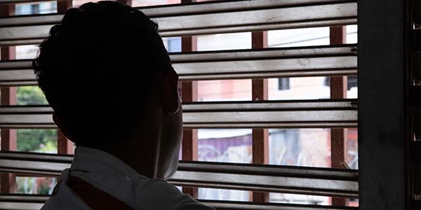 A boy looks out a window. A boy looks out a window.