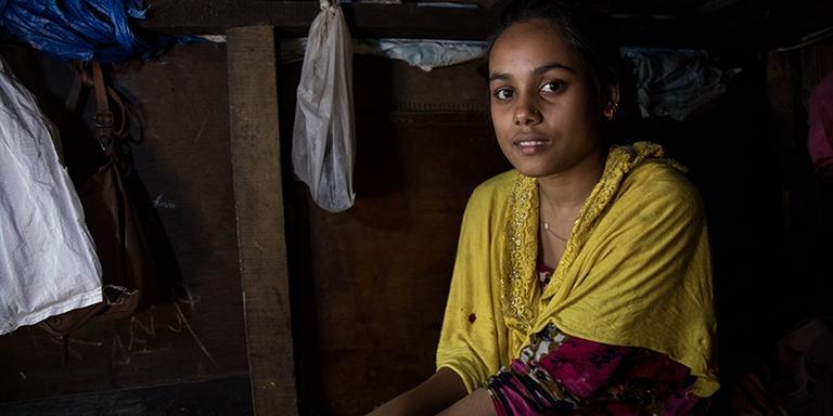 India, a Save the Children child champion, inside her home haphazardly patched together with wood panels India, a Save the Children child champion, inside her home haphazardly patched together with wood panels
