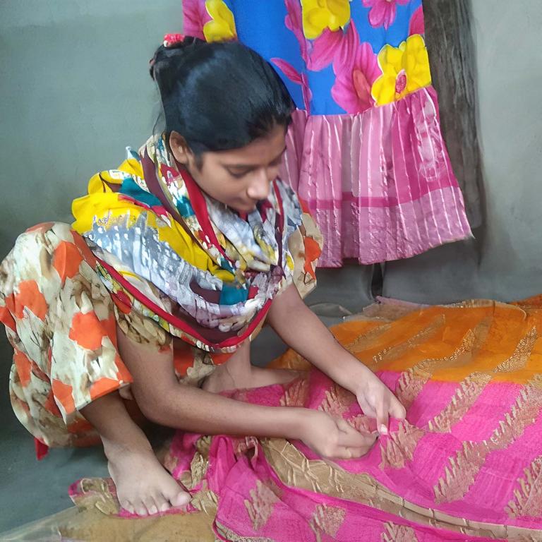 Young girl sewing a pink and gold mat Young girl sewing a pink and gold mat