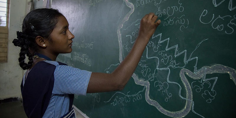 A girl from India stands in front of a chalk board A girl from India stands in front of a chalk board