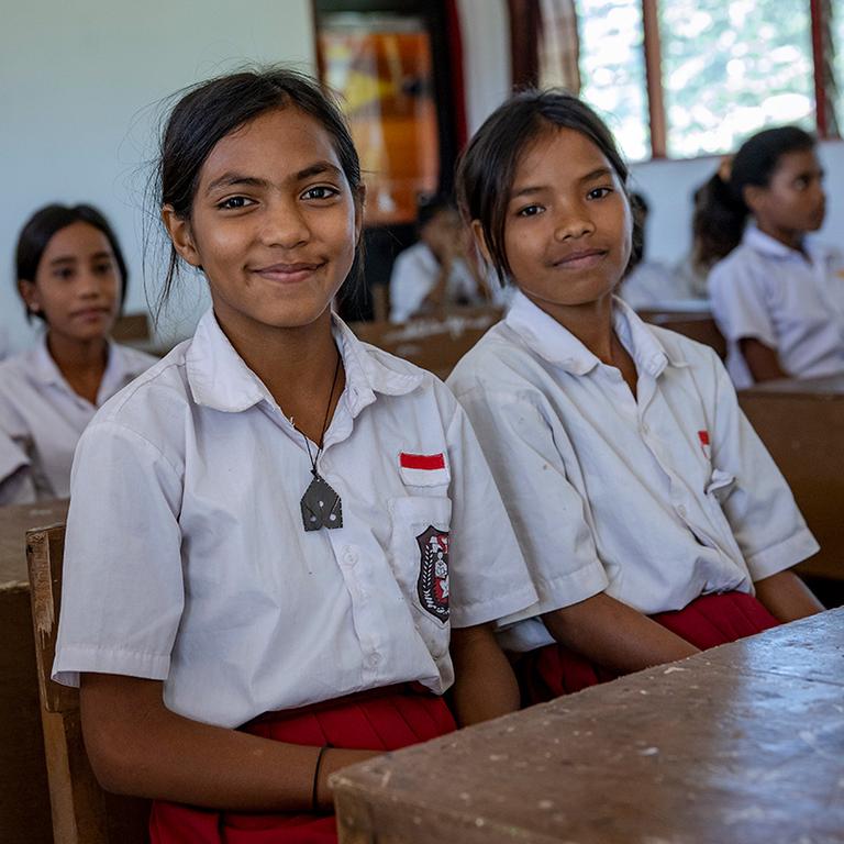 In Indonesia, Atika, 12, sits at a desk next to a classmate at her school. In Indonesia, Atika, 12, sits at a desk next to a classmate at her school.