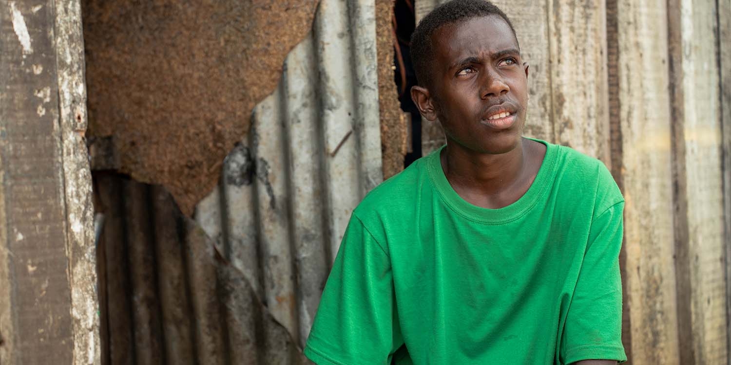 Vanuatu, a teenage boy in a green t-shirt looks away from the camera Vanuatu, a teenage boy in a green t-shirt looks away from the camera