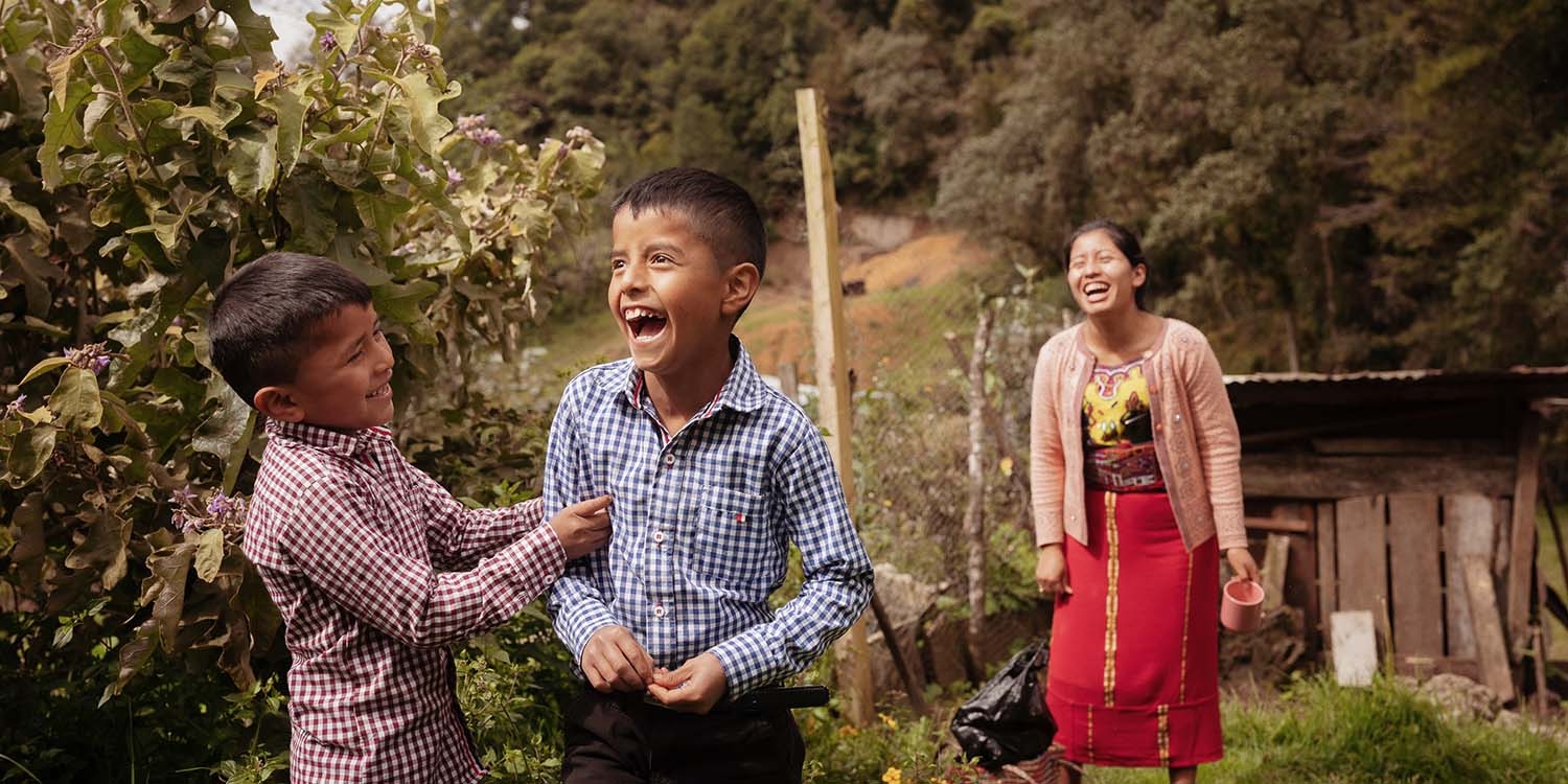 Guatemala, a mother and her two sons laugh together on their farm Guatemala, a mother and her two sons laugh together on their farm