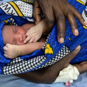 A two-day-old baby is wrapped in a brightly colored blanket and held by a health worker at the County Referral Hospital in Kenya. CHX was used on the baby’s ambilitical cord to prevent post-natal infection. Photo credit: Siegfried Modola / Save the Children, Aug 2018. A two-day-old baby is wrapped in a brightly colored blanket and held by a health worker at the County Referral Hospital in Kenya. CHX was used on the baby’s ambilitical cord to prevent post-natal infection. Photo credit: Siegfried Modola / Save the Children, Aug 2018.