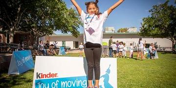 A little girl jumps in the air at a Ferrero Kinder Joy of Moving event. A little girl jumps in the air at a Ferrero Kinder Joy of Moving event.