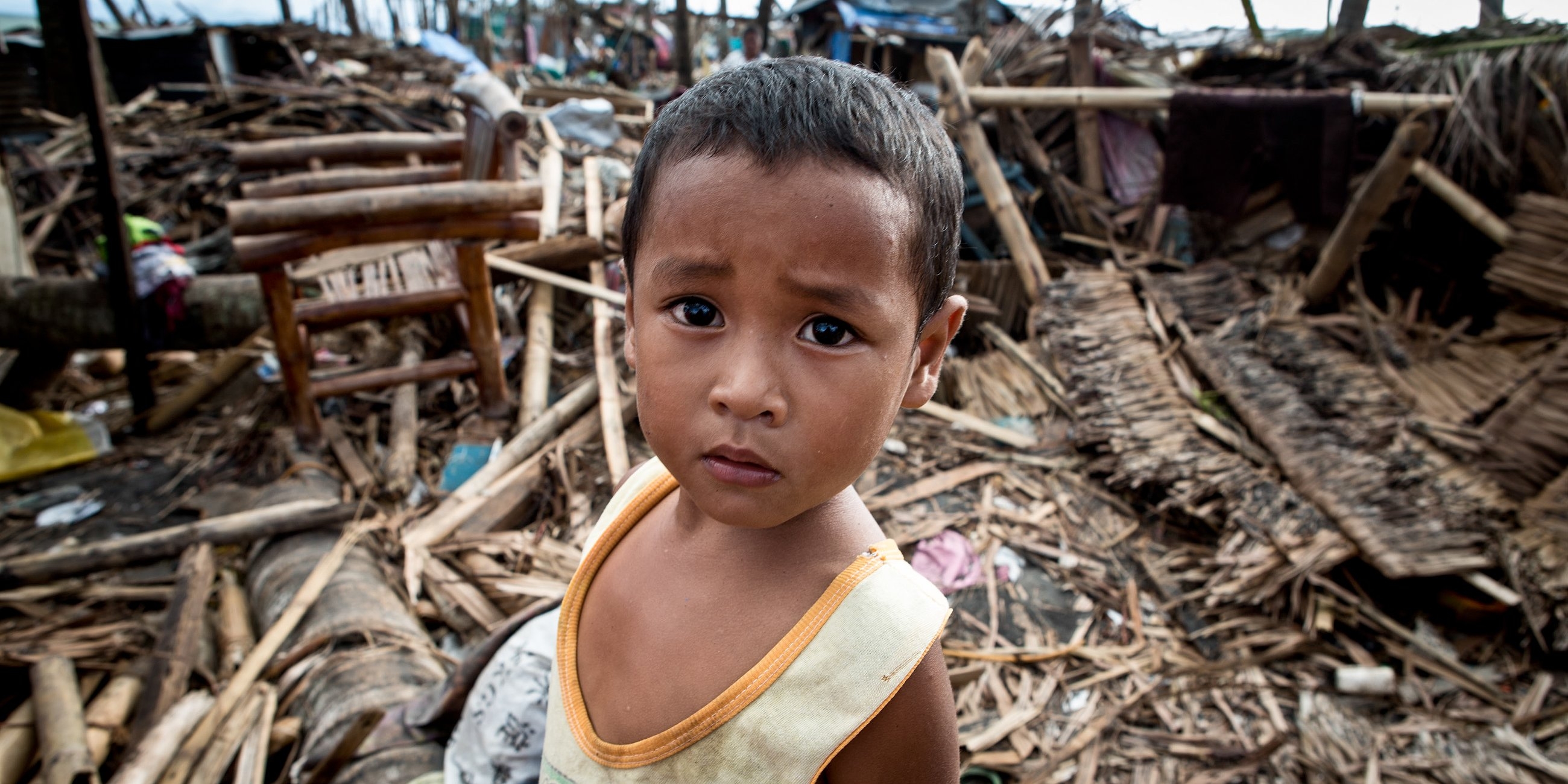 Kirby, four, stands amongst the debris where his house once stood before it was destroyed by typhoon