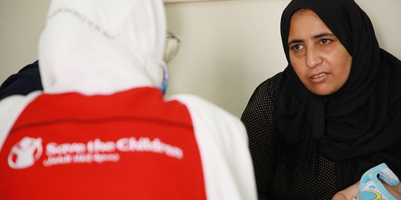 Lina speaks with a Save the Children aid worker. Lina speaks with a Save the Children aid worker.