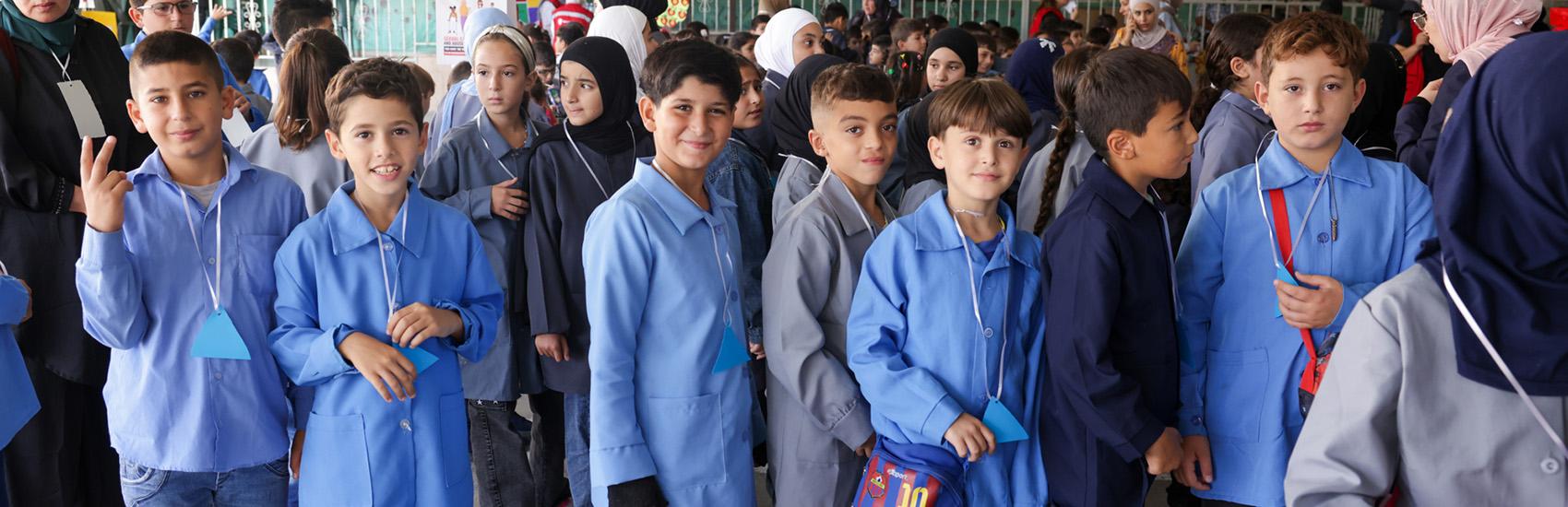 In Lebanon, a group of boys stand in line in blue school uniform shirts