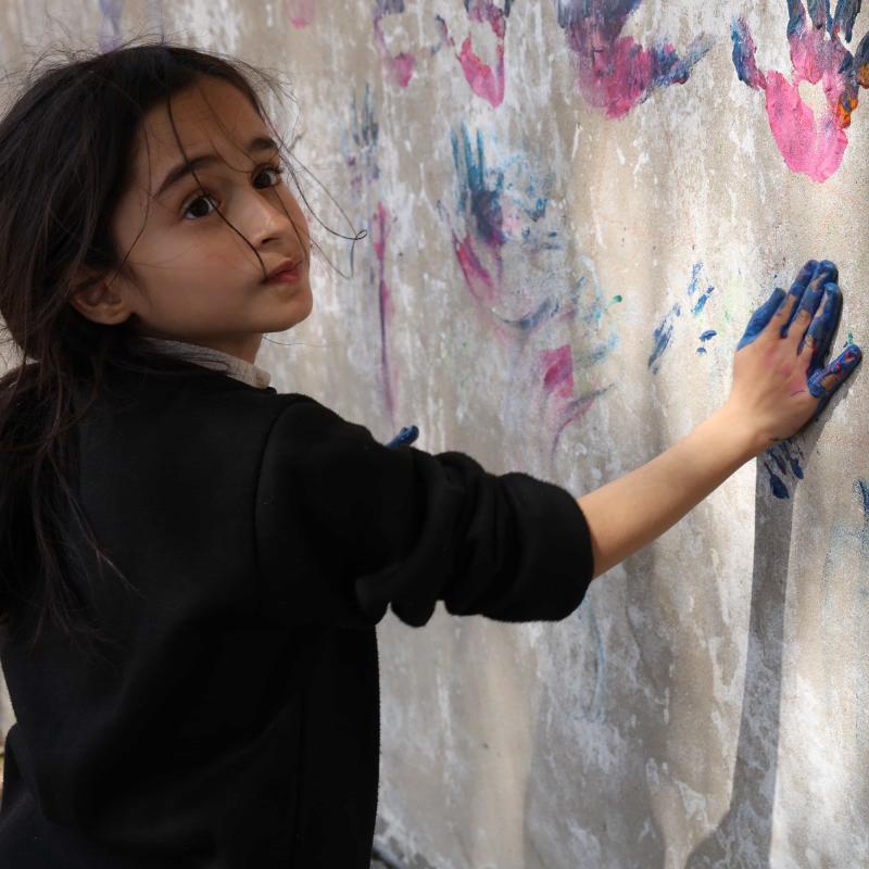 Nine-year-old girl paints with her hands in child friendly space