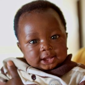 A mother smiles as she holds her 3-month old child at a Save the Children-supported clinic in Louisiana, Montserrado county, Liberia. In 2013, Save the Children raised $500,000 to build six new health facilities in some of the poorest and most remote health districts across two counties of Liberia. These health clinics are providing vital, life-saving medical services to the 40,300 people who currently have limited access to any kind of proper healthcare. Photo credit: Magda Rakita/Save the Children, Januar A mother smiles as she holds her 3-month old child at a Save the Children-supported clinic in Louisiana, Montserrado county, Liberia. In 2013, Save the Children raised $500,000 to build six new health facilities in some of the poorest and most remote health districts across two counties of Liberia. These health clinics are providing vital, life-saving medical services to the 40,300 people who currently have limited access to any kind of proper healthcare. Photo credit: Magda Rakita/Save the Children, Januar
