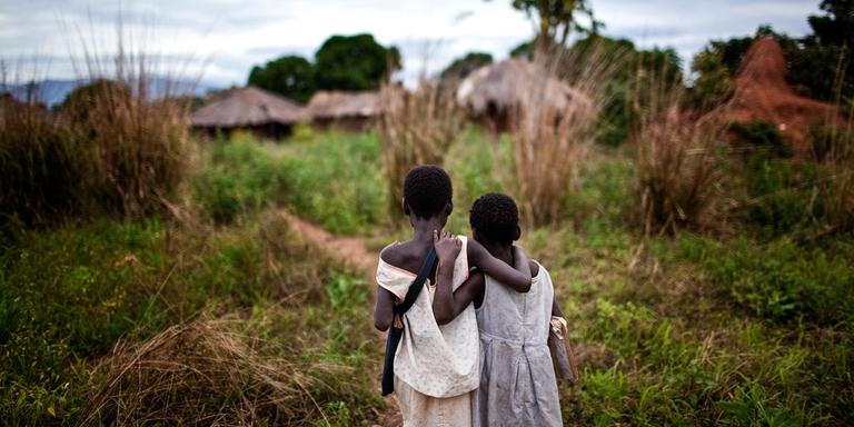 Two young sisters who lost their mother to HIV and AIDS walk home arm-in-arm after school. Photo credit: Save the Children, 2010. Two young sisters who lost their mother to HIV and AIDS walk home arm-in-arm after school. Photo credit: Save the Children, 2010.