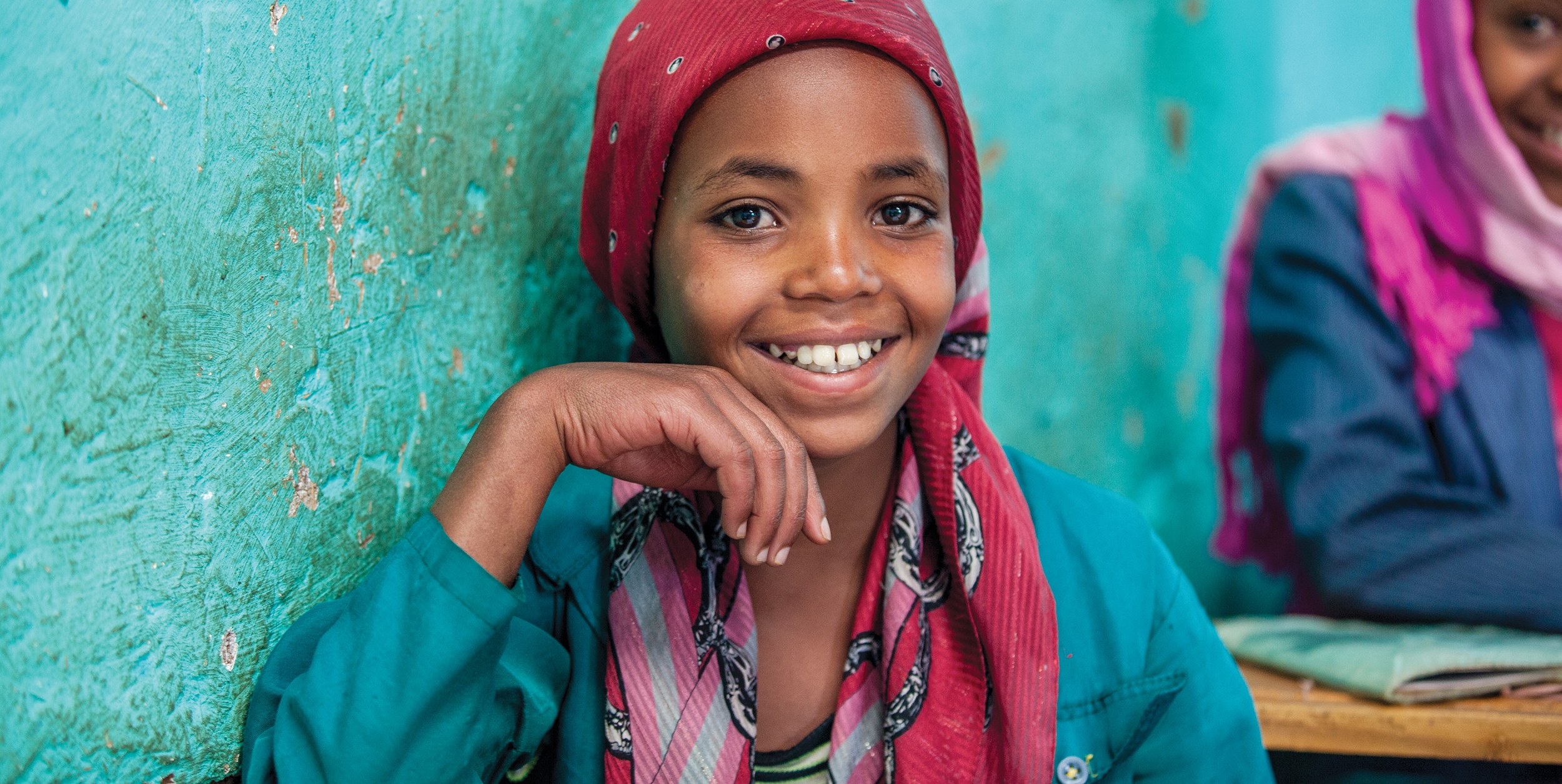 Two schoolgirls – Asiah and Rashina – smile brightly at a Save the Children education center in Zomba, Malawi. Photo credit: Jordan J. Hay/Save the Children, 2017. 
