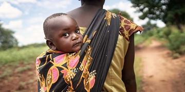 Memory with her son Joseph in a sling on her back, in Malawi. Memory with her son Joseph in a sling on her back, in Malawi.